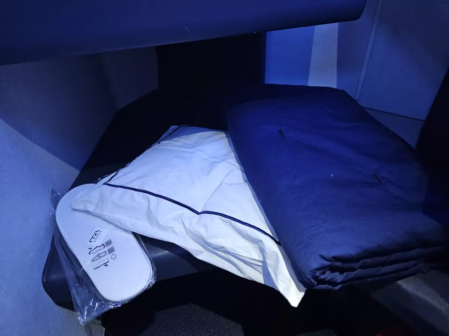 Almofada, cobertor e chinelos