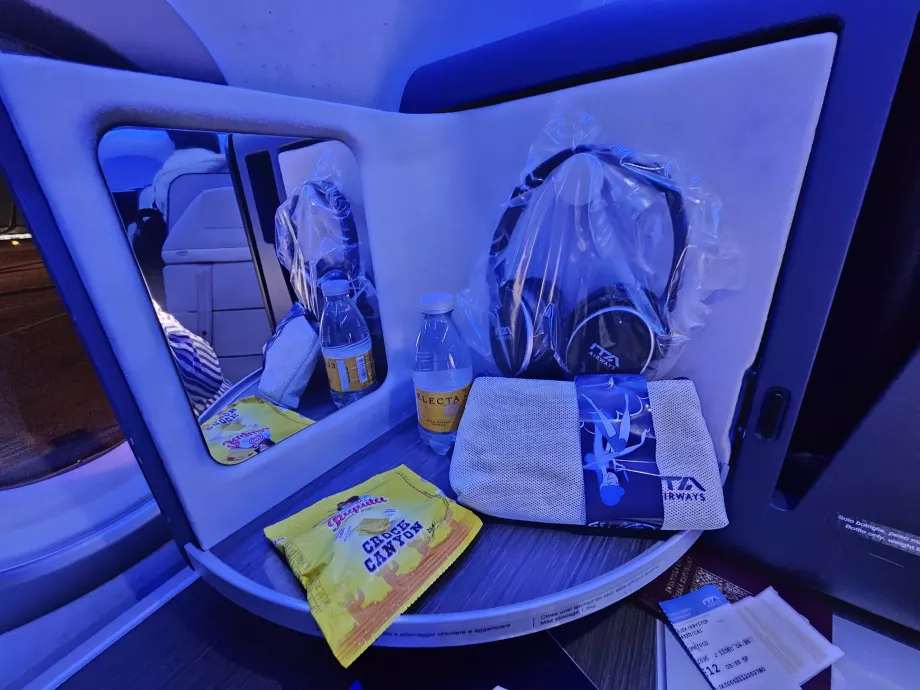 Painel de abertura com espelho, auscultadores, bolachas e água