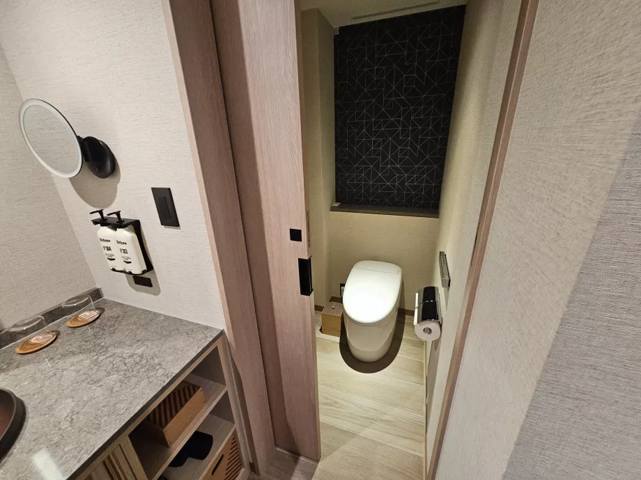 Casa de banho separada do resto da casa de banho por uma porta