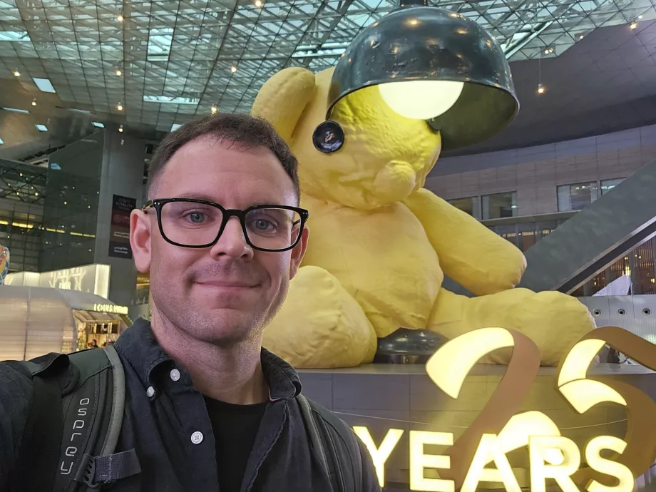 Eu em frente a um urso amarelo com um candeeiro
