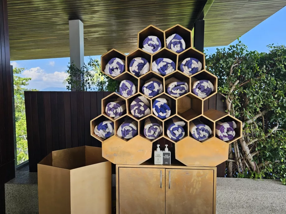 Toalhas e protetor solar junto à piscina